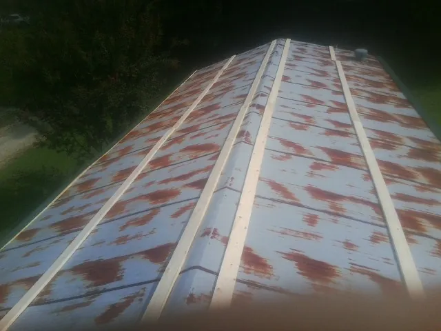 Rusted metal roof panels with new wood purlins before replacement — Storm Damage Roof Repair in Union Springs by Roofing Brothers